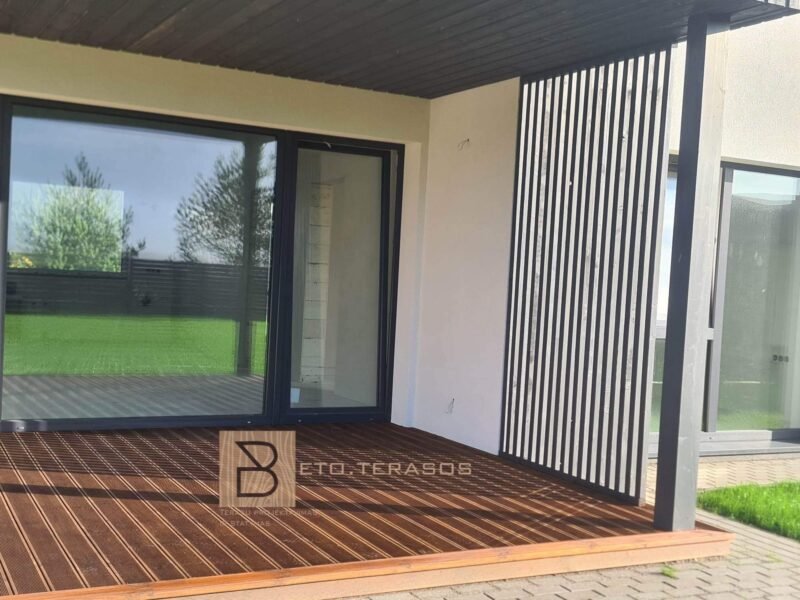 Medinė terasa po stogine prie balto namo