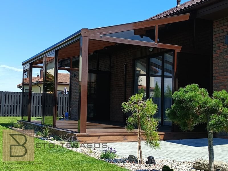 Įstiklinta veranda prie namo su medžiu