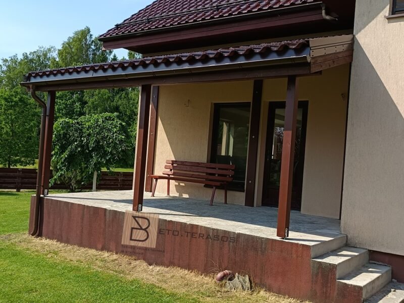 Stoginė prie geltono namo su suoliuku