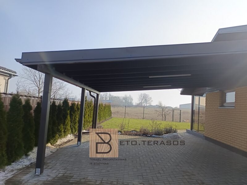 Tamsi automobilių pastogė prie namo