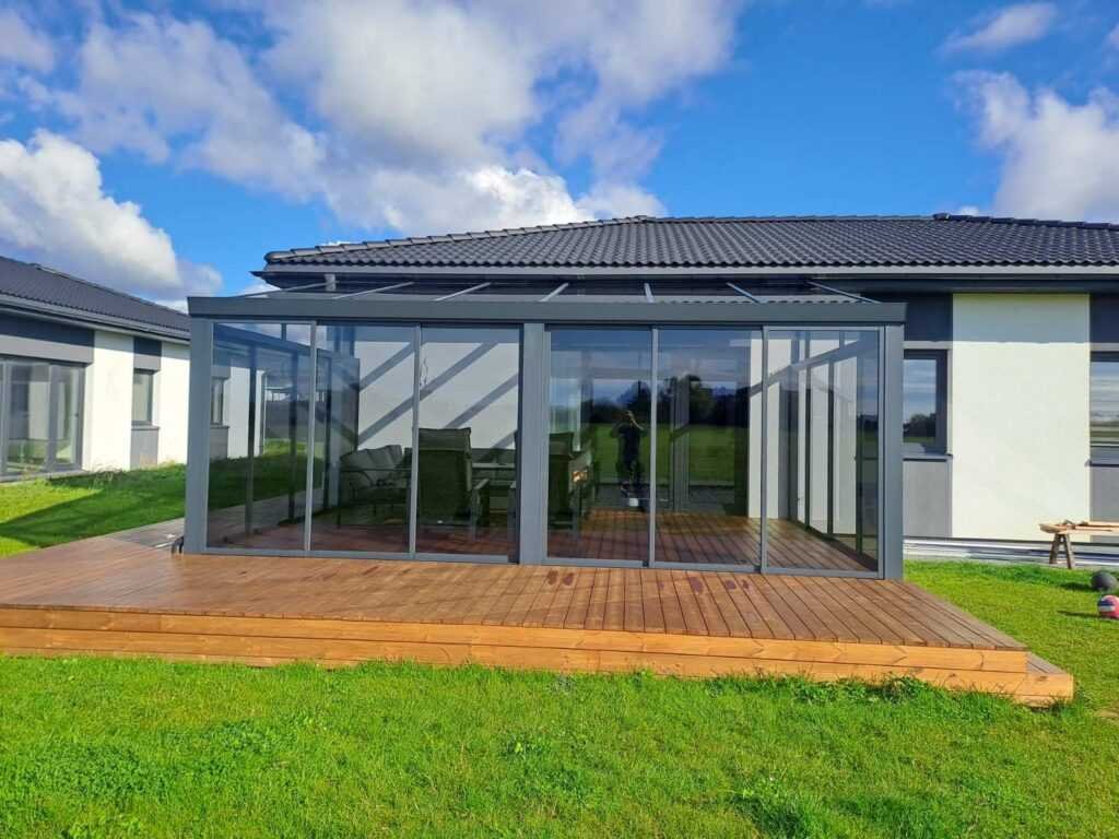 Įstiklinta veranda su plačia medine terasa