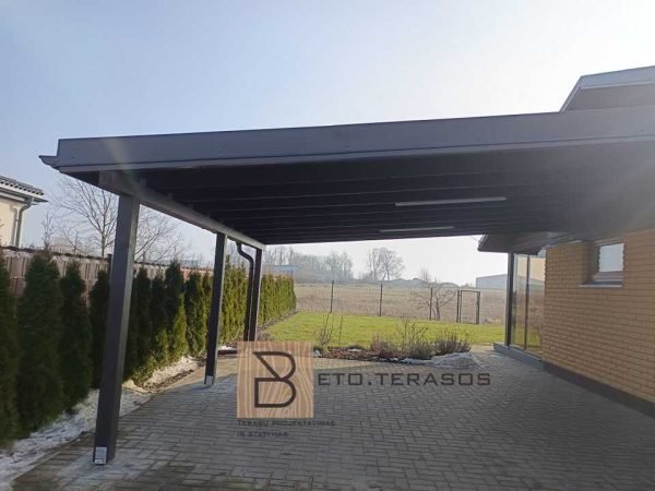 Tamsi automobilių pastogė prie namo